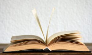 Close-up image of an open book with pages turning, creating a dynamic visual.